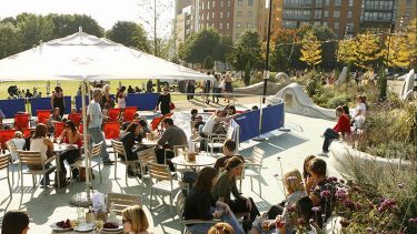 People sitting round tables on the patio of Devonshire Green