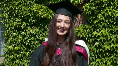 A woman wearing a graduation cap and gown