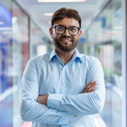 Sajid Bashir wearing a light blue short with his arms folded.